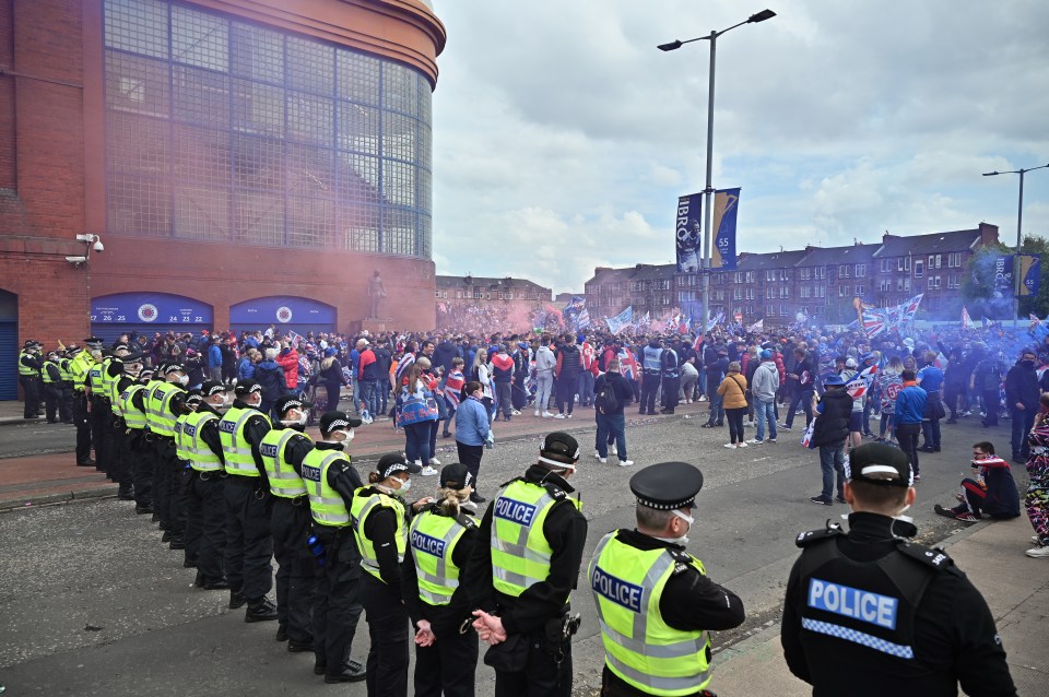 Police line up as fans celebrate winning the Scottish Premiership title in Glasgow in 2021 in Glasgow