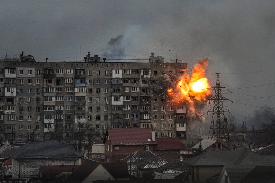 An explosion erupts from an apartment building in Mariupol, Ukraine