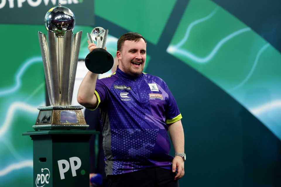 Luke Littler holding the runner-up trophy at the World Darts Championship.