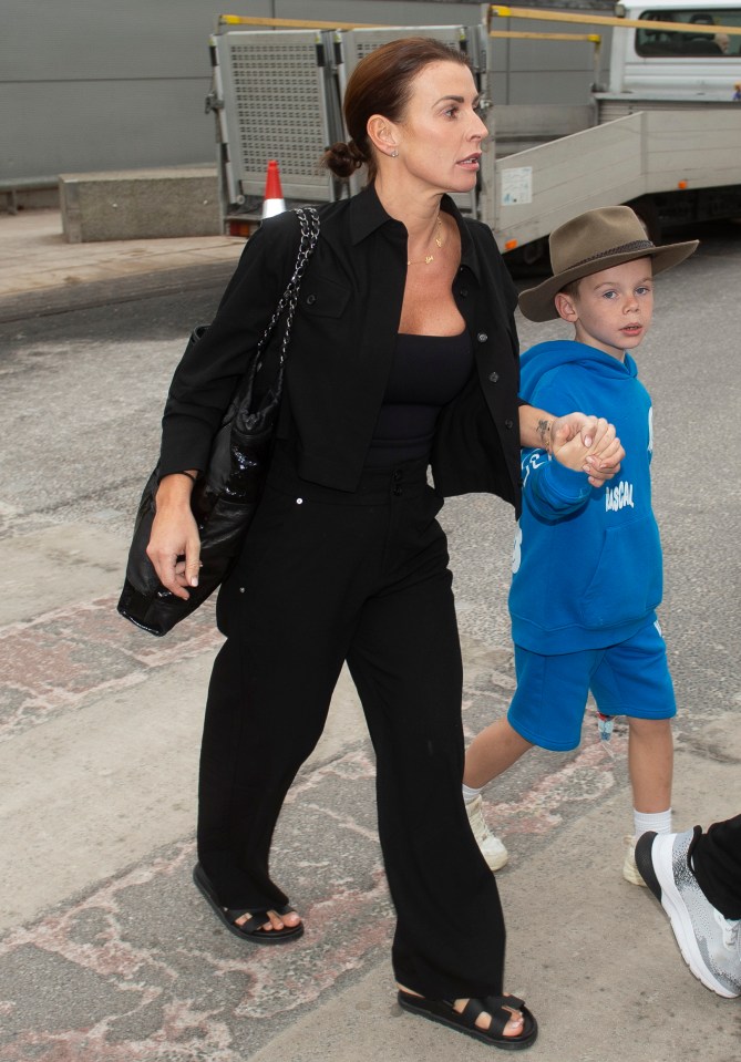 Son Cass sported Coleen's I'm A Celebrity jungle hat as they made their way through the airport