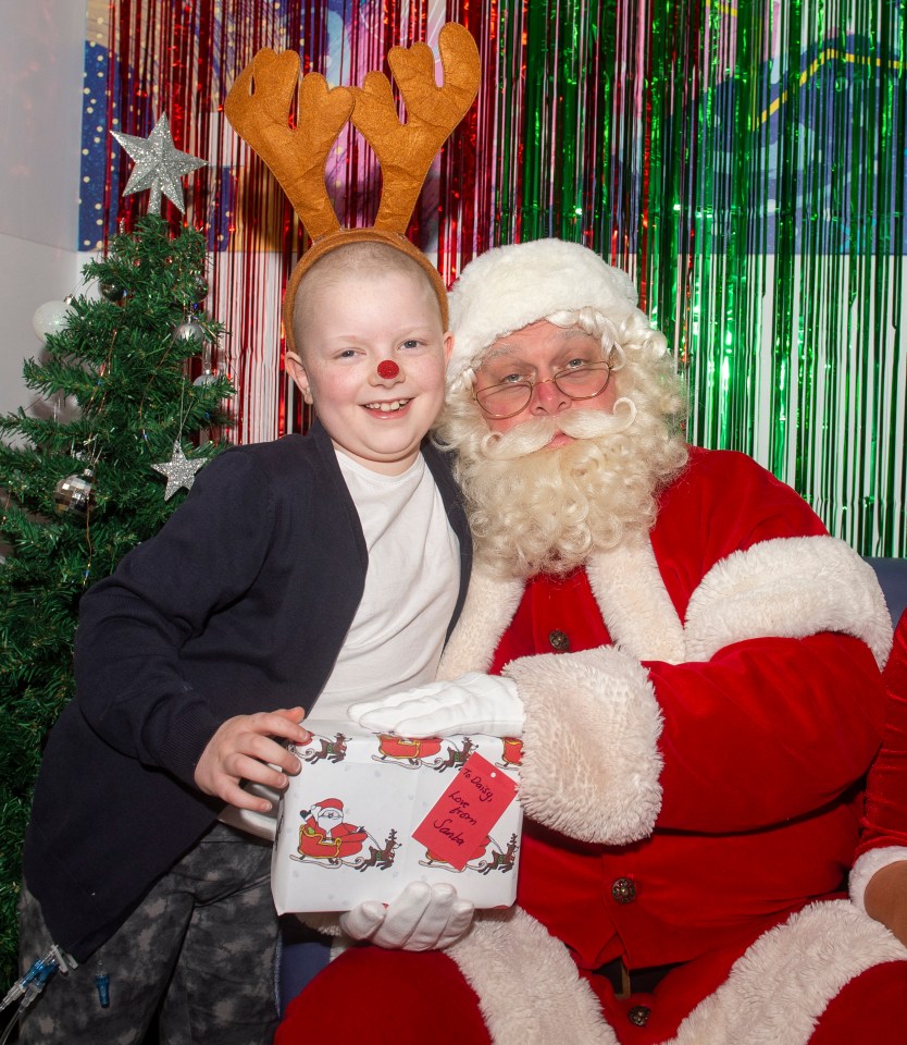 Daisy Tullett with Santa and Mrs. Claus at Birmingham Children's Hospital.