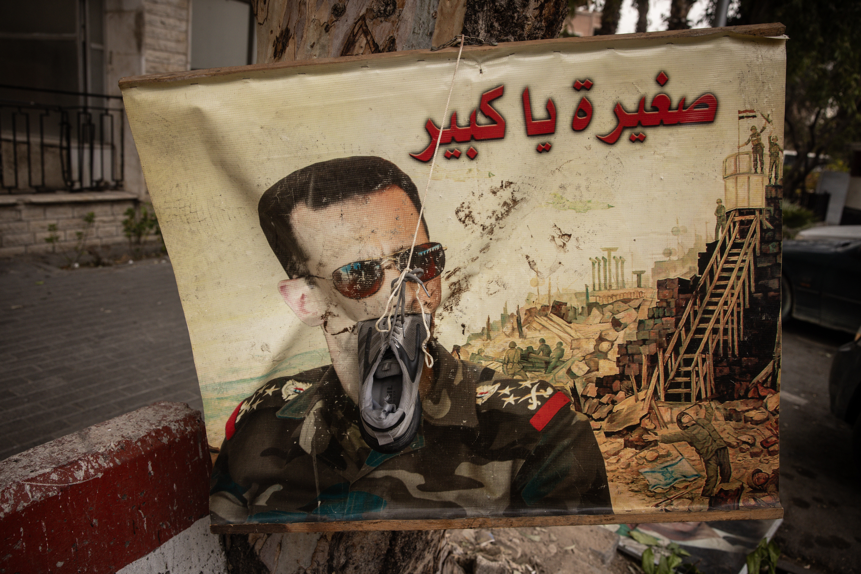 A defaced poster of Bashar al-Assad in Damascus