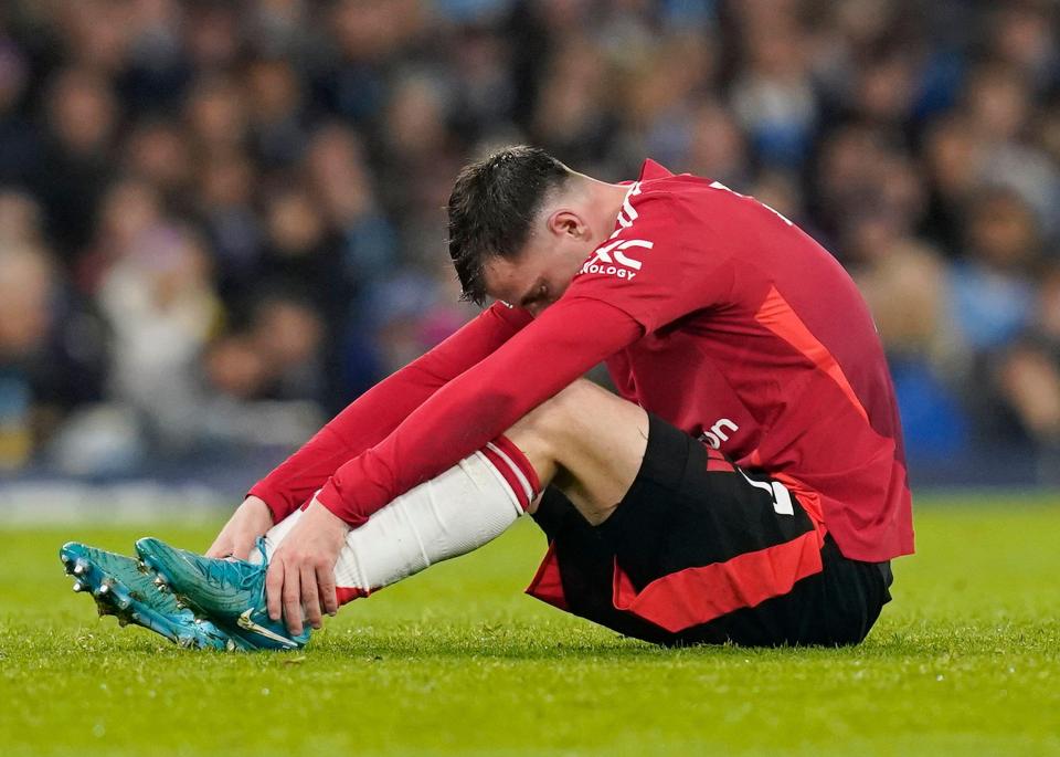 Injured Mason Mount of Manchester United sits on the field.