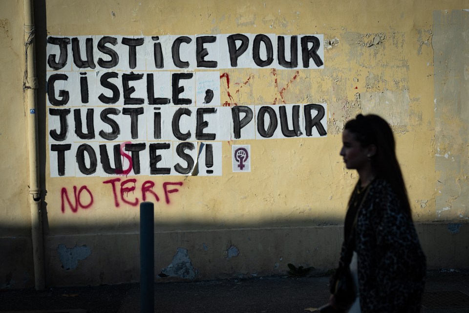 A pedestrian walks past a collage mural reading 'Justice for Gisele, Justice for all'