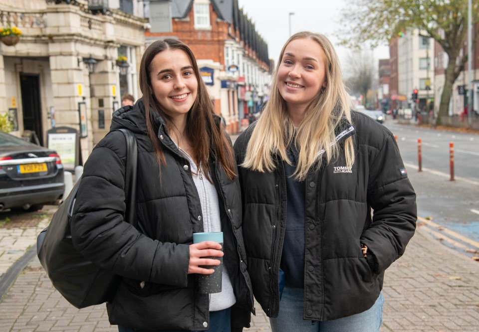 Two Birmingham University physiotherapy students stand on a city street.