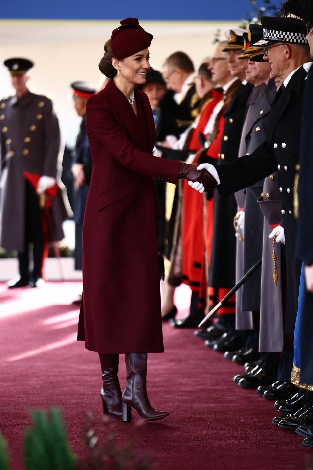 Princess Catherine shaking hands with a dignitary at a ceremonial welcome.