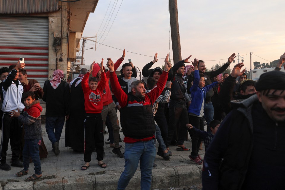 Residents cheer Syrian anti government fighters as they enter the west-central city of Hama