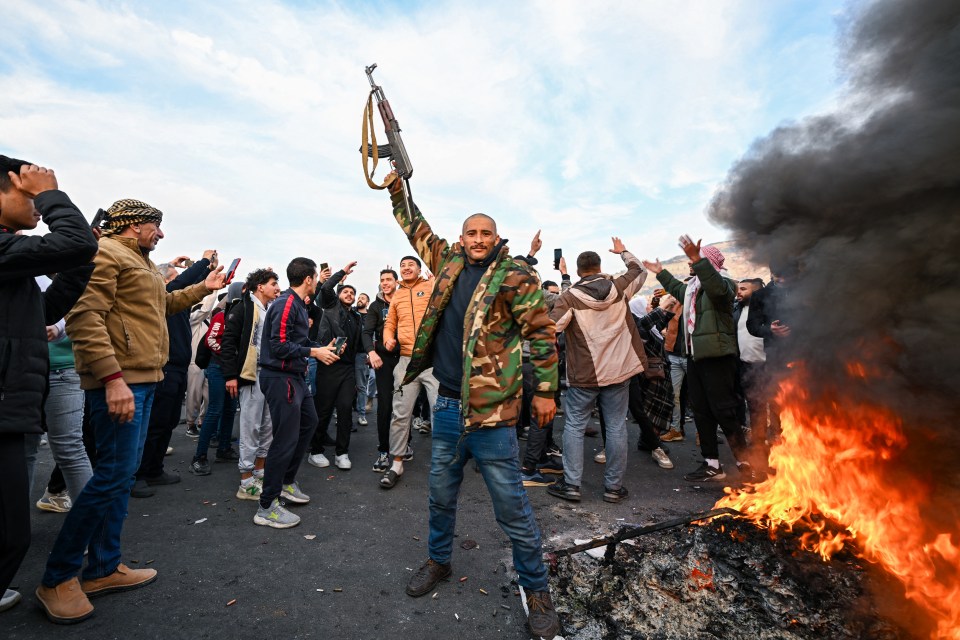 Fighters celebrate at Umayyad Square in Damascus on Sunday morning