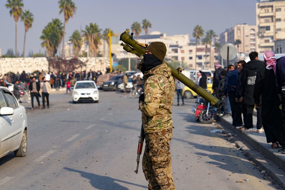 A Syrian anti government fighter carries a shoulder-held surface-to-air missile launcher