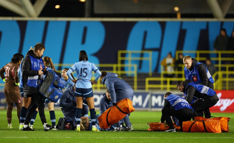 Manchester City's Alex Greenwood receiving medical attention on the field.