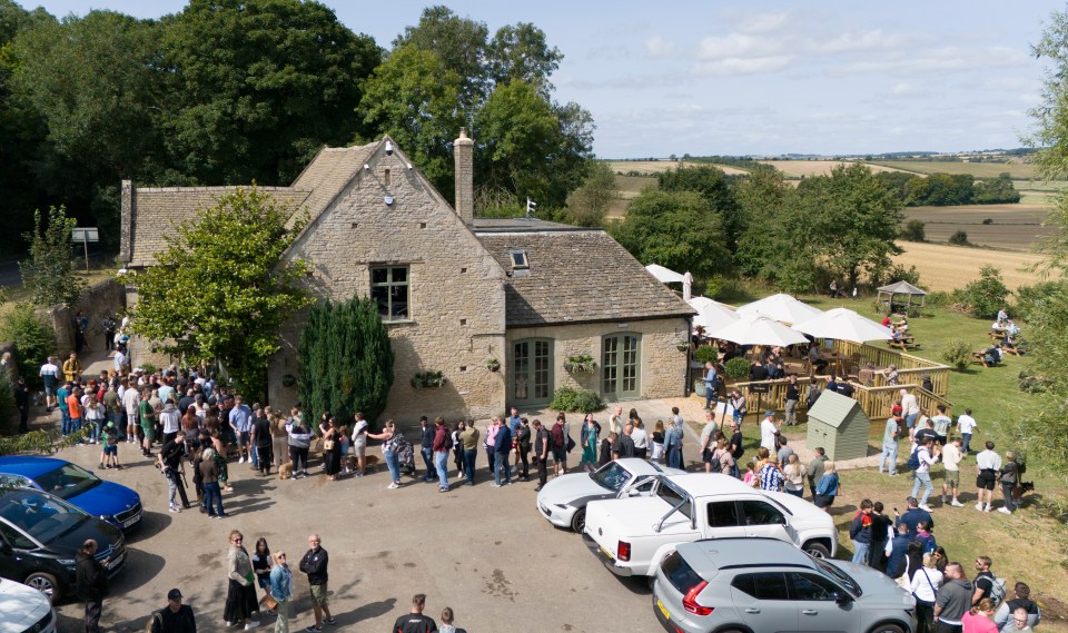 Aerial view of a long queue of people outside The Farmer's Dog pub.