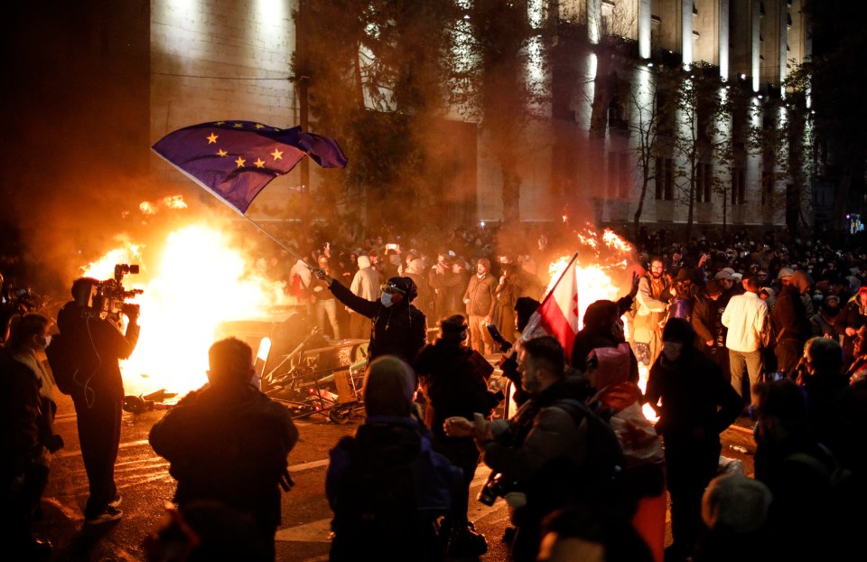 Georgian opposition supporters protest in front of the Parliament building in Tbilisi