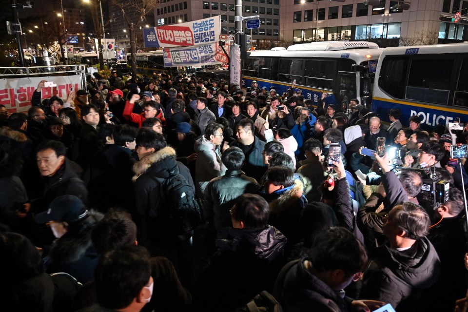 People gather in front of the main gate of the National Assembly in Seoul