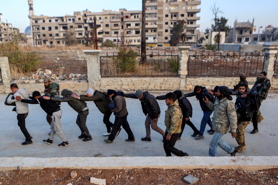 Syrian rebel fighters parade detained members of the Syrian government’s forces