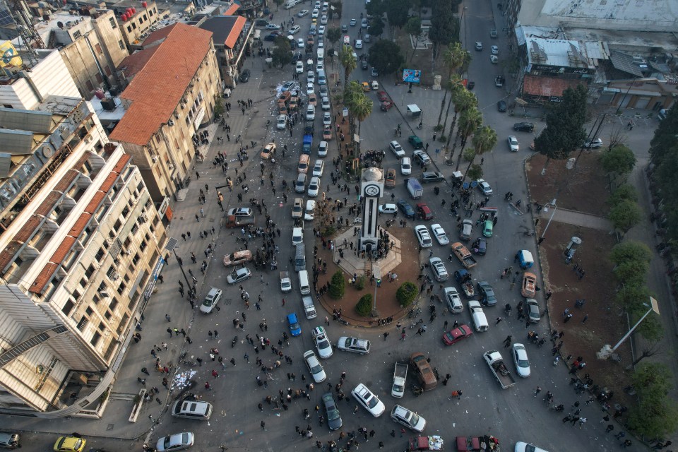 Syrian rebel fighters and civilians celebrating at the Clock Tower in the central city of Homs on Sunday