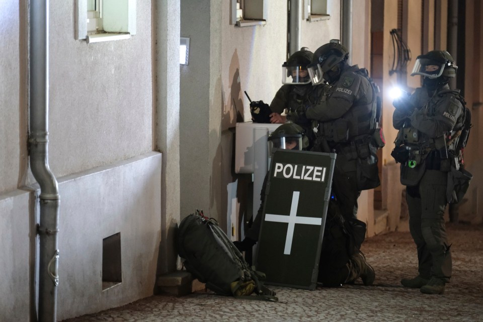 Police stand outside Taleb's home in the early hours of Saturday morning