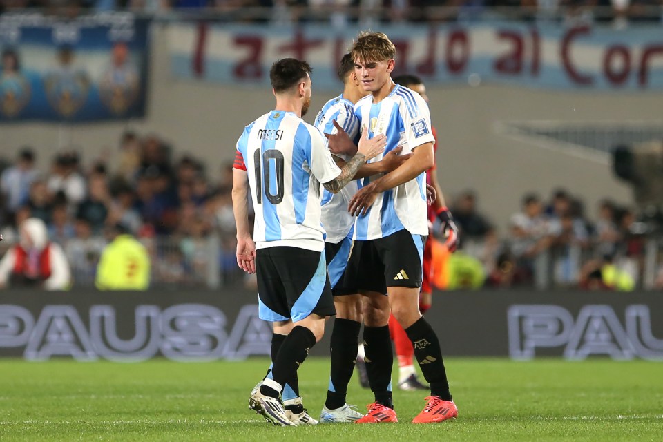 Lionel Messi congratulates a teammate after an Argentina victory.