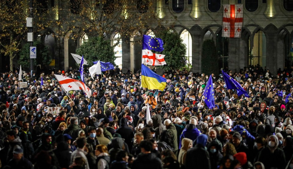 Georgian opposition supporters protest in front of the Parliament building in Tbilisi