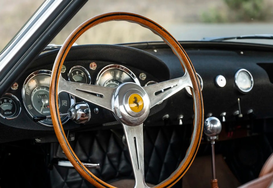 The wooden steering wheel is adorned with the famous prancing horse logo