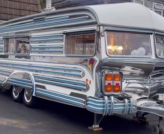 Chrome caravan parked in a driveway.