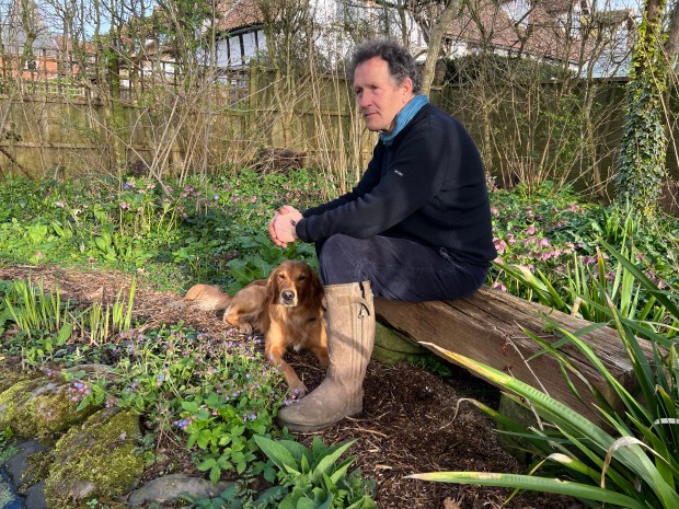 Monty Don with his dog, Ned, in his garden.