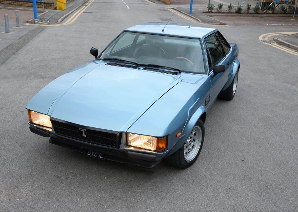 Light blue De Tomaso Longchamps parked on a street.