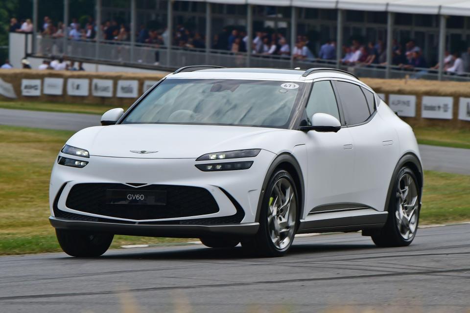 White Genesis GV60 driving on a track.