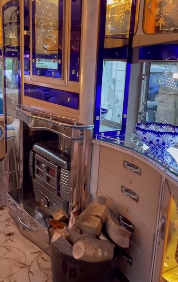 Interior of a luxury caravan, showing a fireplace and ornate cabinetry.