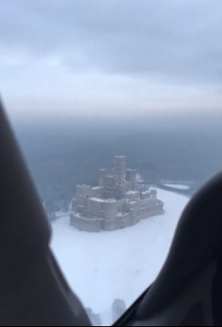 Aerial view of a medieval castle on a frozen lake.