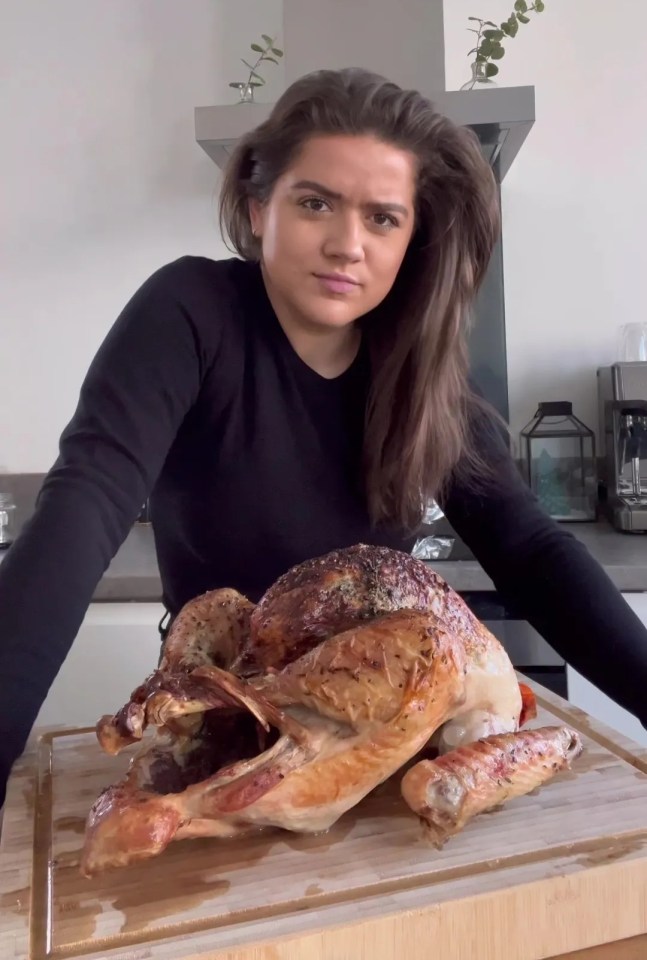 Woman presenting a roasted turkey.