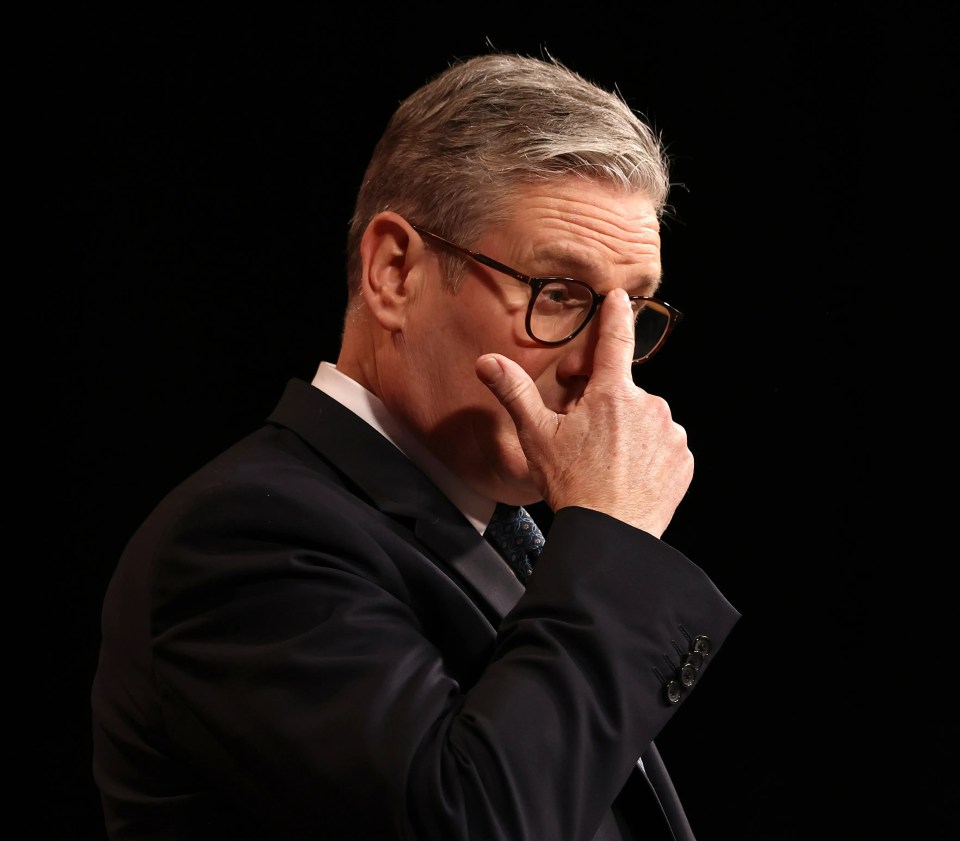 Keir Starmer adjusting his glasses while giving a speech.