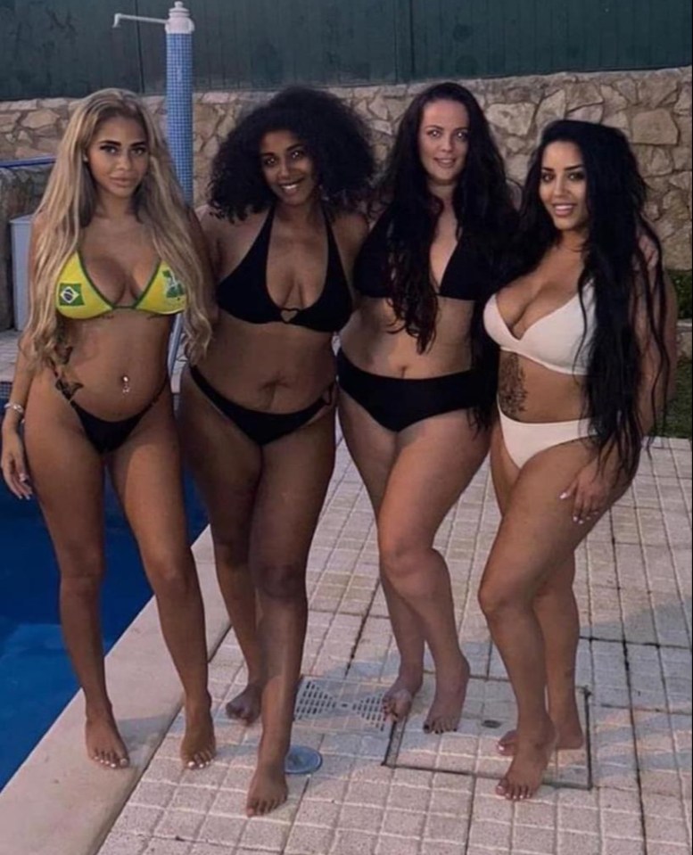 Four women in swimsuits by a pool.