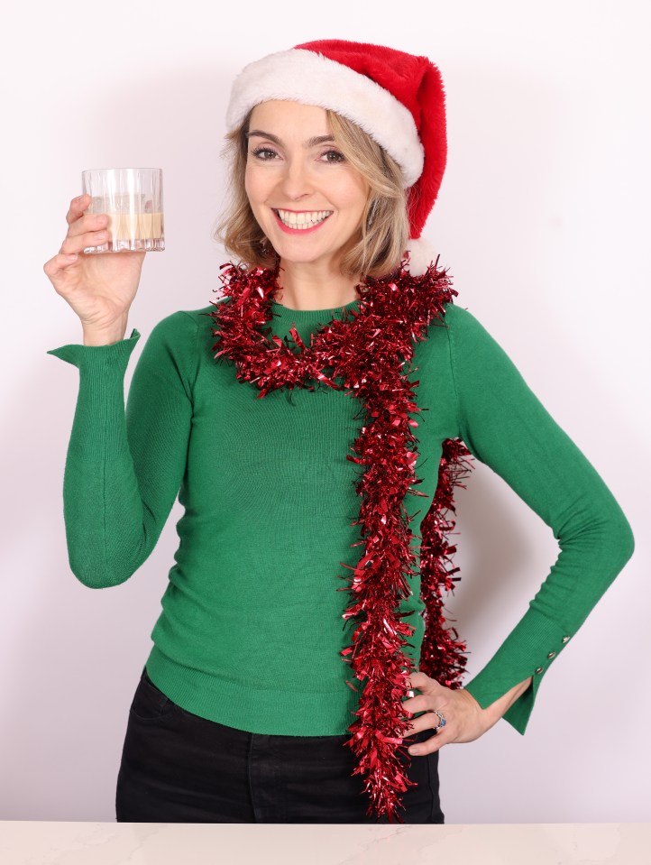 Woman in Santa hat holding a Christmas drink.