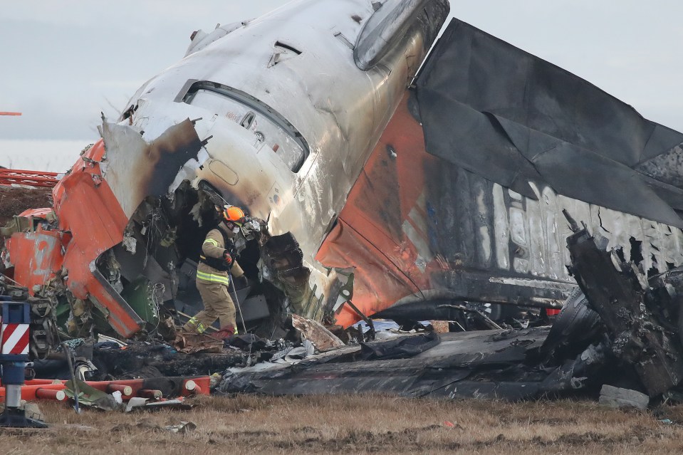 Firefighter at the wreckage of a crashed passenger plane.