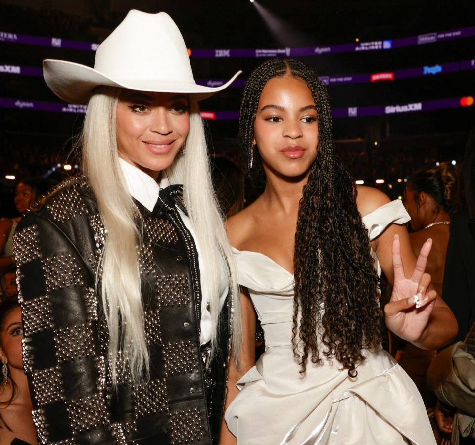 a woman in a cowboy hat stands next to a woman in a white dress