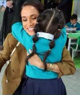 Meghan hugs a schoolchild