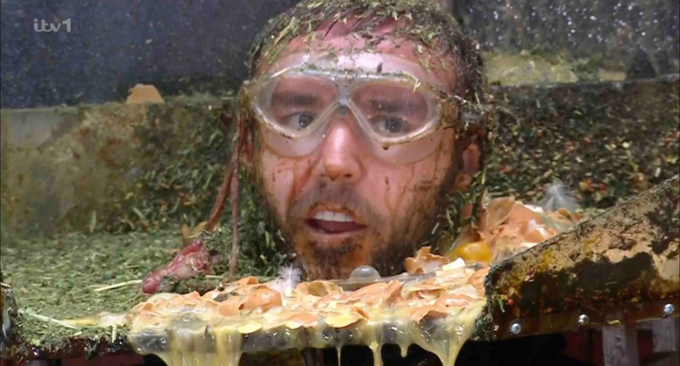 A man's head and shoulders covered in mud and eggs during a bushtucker trial.