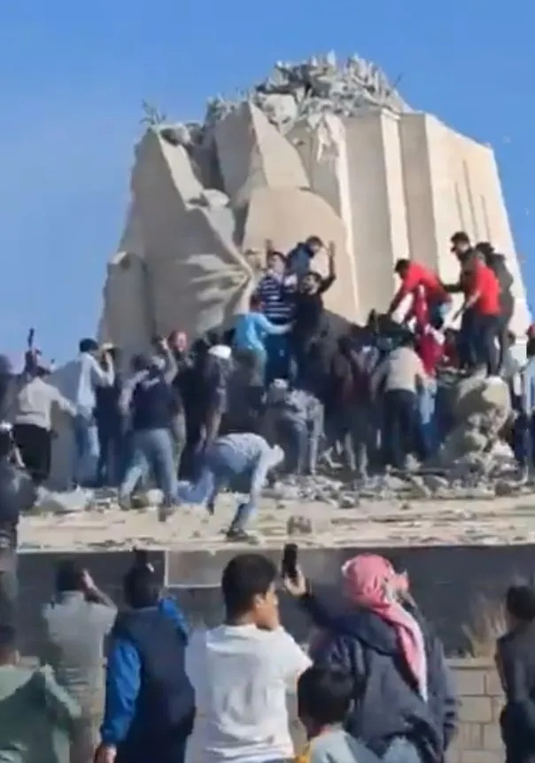 Hundreds of rebels quickly jumped on the statue's remains to celebrate