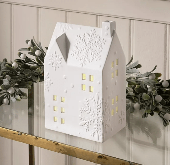 White ceramic house-shaped light with snowflake and floral designs.