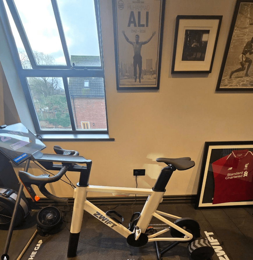 White Zwift smart bike trainer in a home gym.