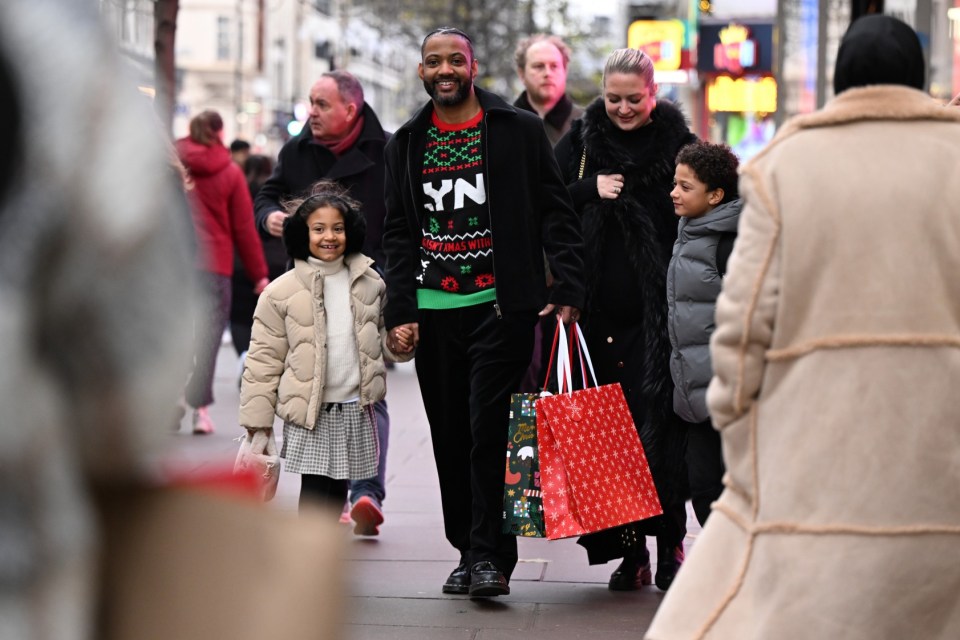 LONDON, ENGLAND - DECEMBER 17: Nothing says Christmas like Lynx Africa: Strictly Come Dancing finalist JB Gill gets into the festive spirit in his Lynx Christmas Jumper whilst out Christmas shopping on Oxford Street, on December 17, 2024 in London, England. (Photo by Jeff Spicer/Getty Images for Lynx)