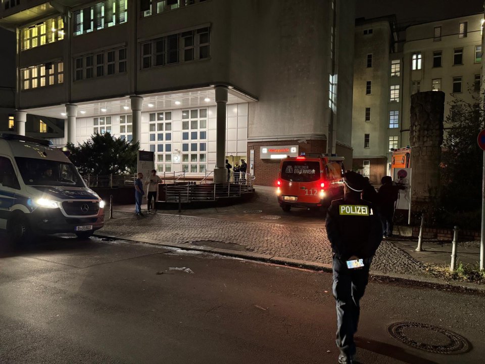 Police and fire vehicles outside a hospital at night.