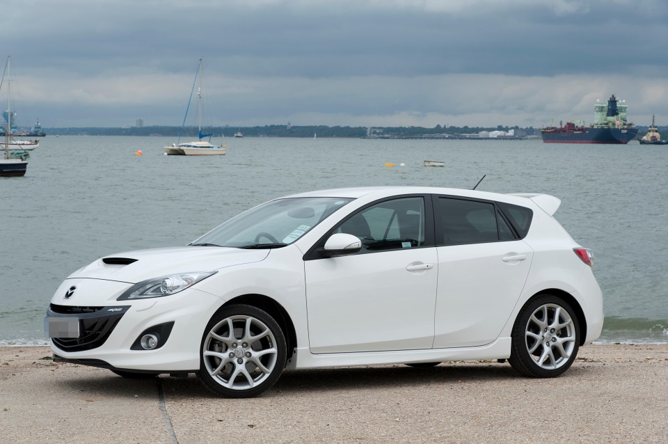 White Mazda 3 MPS hatchback parked by the sea.