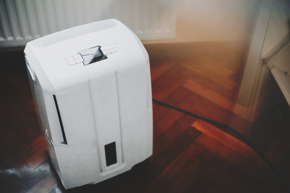 White dehumidifier on hardwood floor.