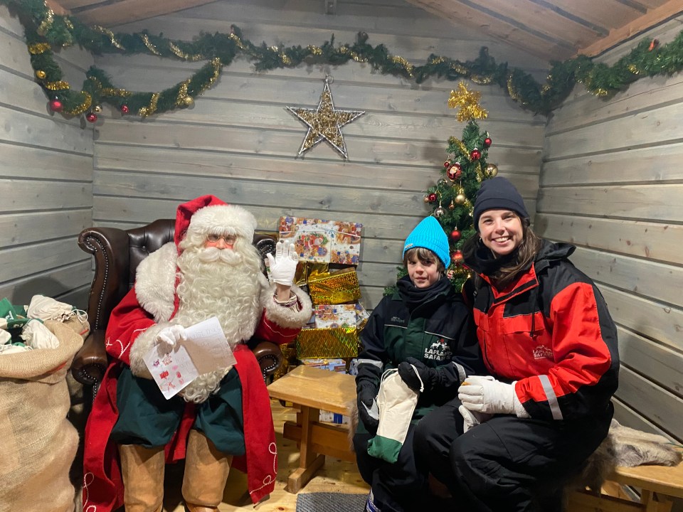 Santa Claus with a child and adult in Lapland.