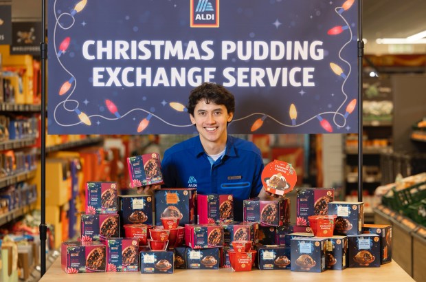 Aldi employee displays various Christmas puddings for the store's exchange service.