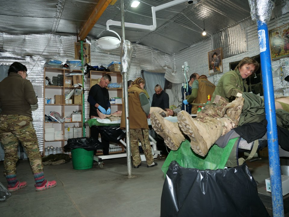 Medical personnel treating a wounded soldier in a field hospital.