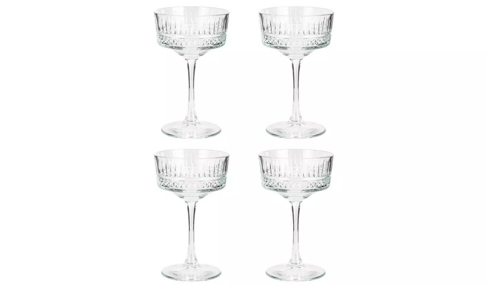 Four empty, stemmed coupe glasses.