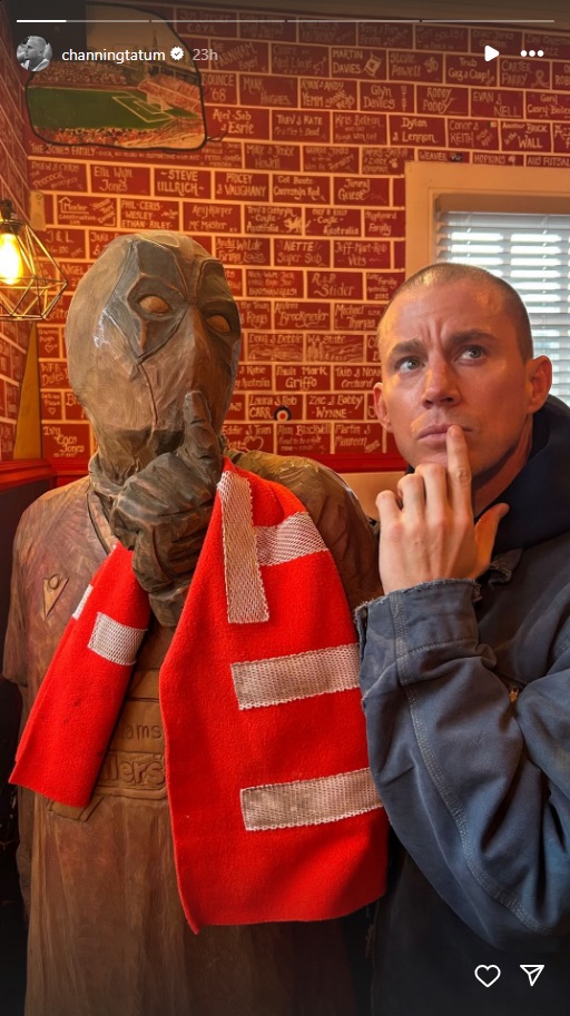 Channing Tatum posing with a Deadpool statue and a red scarf.