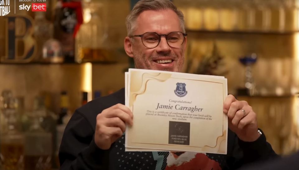 Jamie Carragher holding a certificate confirming his brick will be placed at the new Everton stadium.